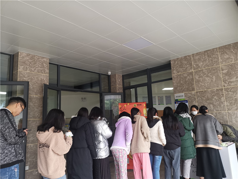 同学有序地排着队来领取爱心粥.jpg