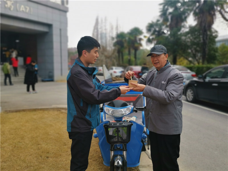 管理员向正在外场保洁员工递上一份爱心粥.jpg