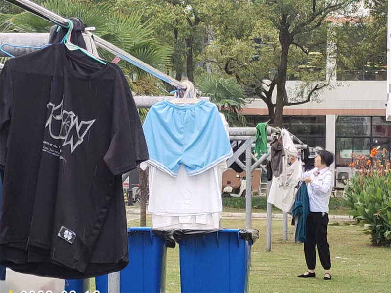 下雨天，值班员帮学生收衣服.jpg