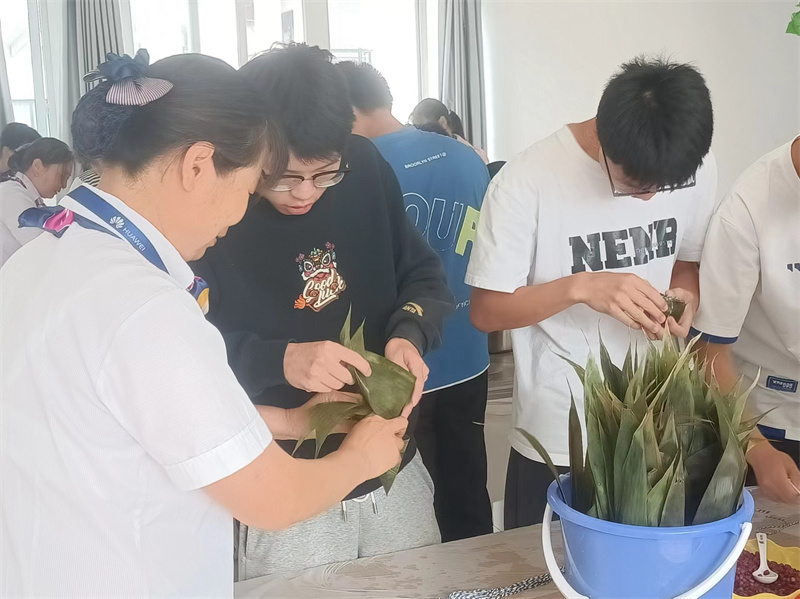 值班阿姨教同学包粽子 (1).jpg