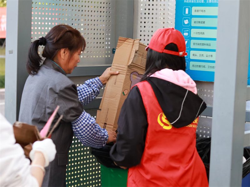 保洁员指导学生进行垃圾分类实践.jpg
