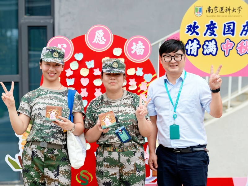 学生与物业管理人员在心愿墙前合影.jpg